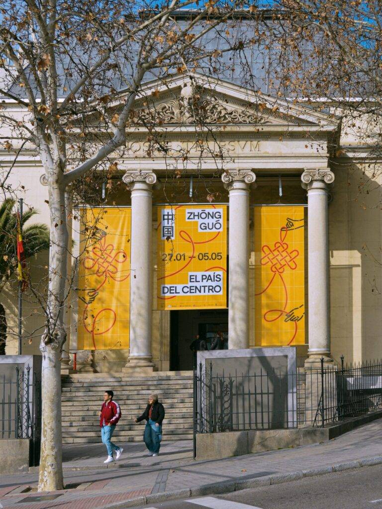 Una fachada de edificio con banners amarillos que anuncian un evento cultural.
