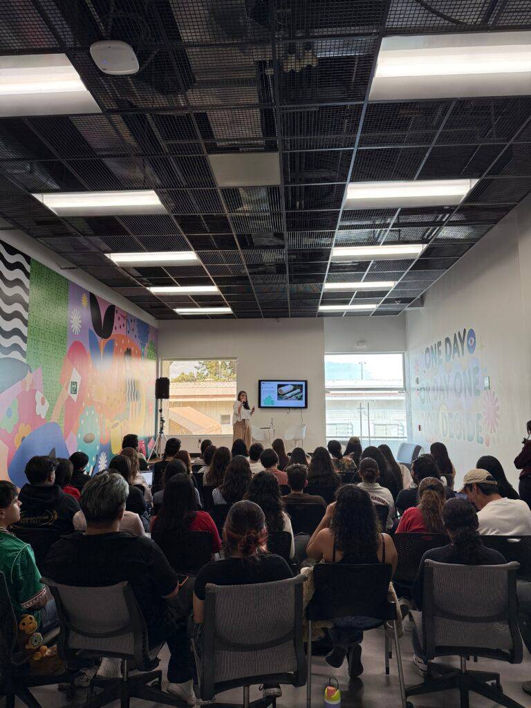Una sala llena de personas asistiendo a una presentación.