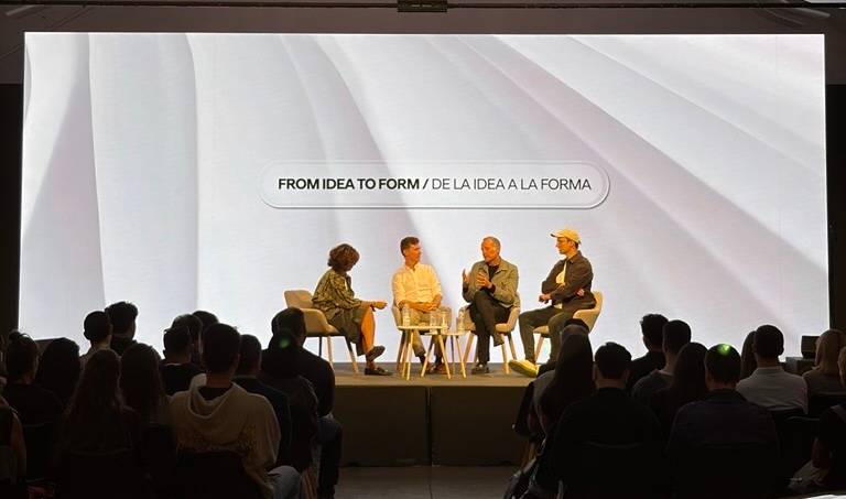 Un panel de discusión sobre el tema 'De la idea a la forma' con cuatro participantes en un escenario frente a una audiencia.