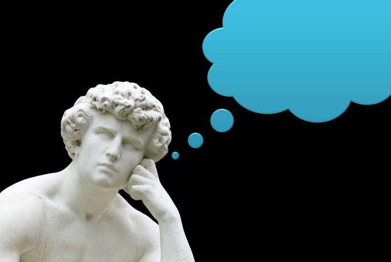 Una escultura clásica de un hombre pensativo con un fondo negro y un globo de pensamiento azul.