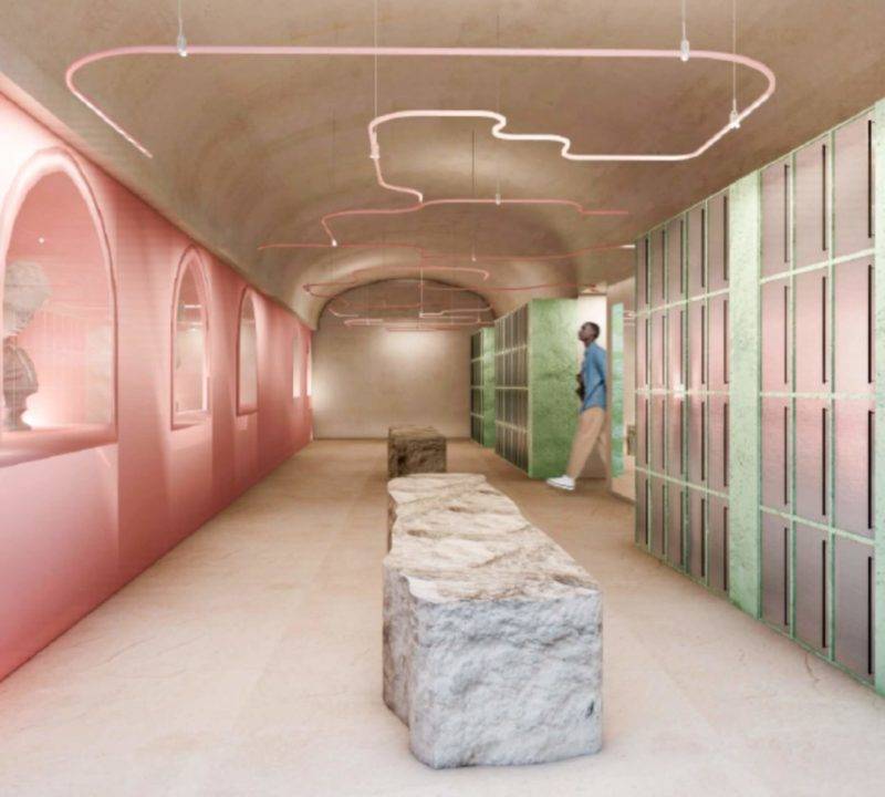 Interiores modernos con paredes rosa, iluminación creativa y una estructura de piedra.
