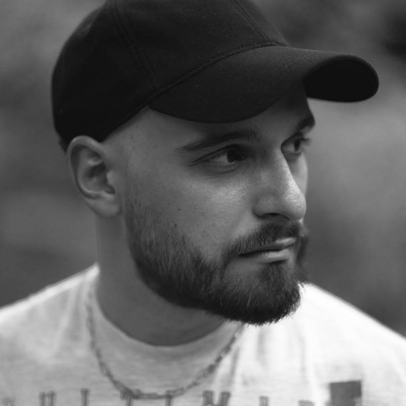 Retrato en blanco y negro de un hombre con barba y gorra.