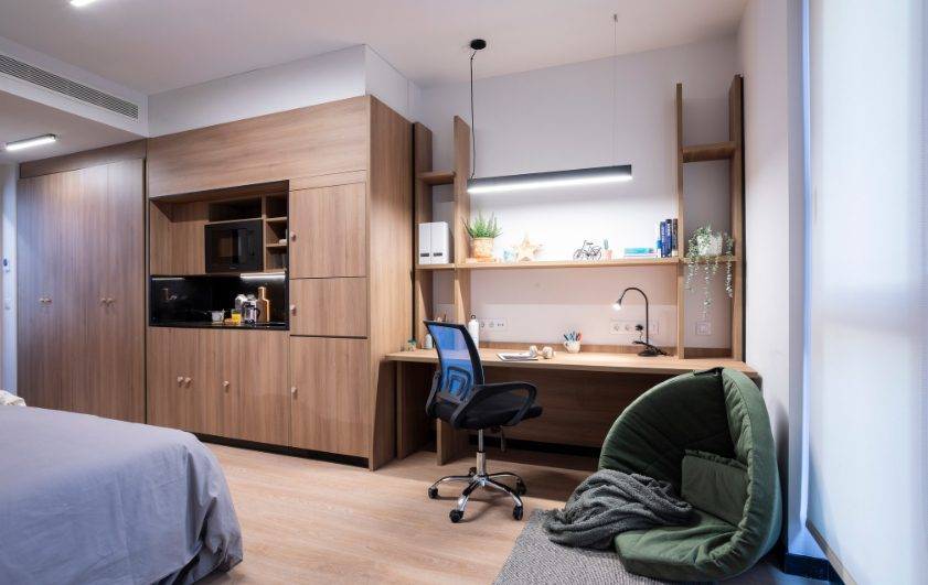 Una habitación moderna y minimalista con muebles de madera y una zona de trabajo funcional.