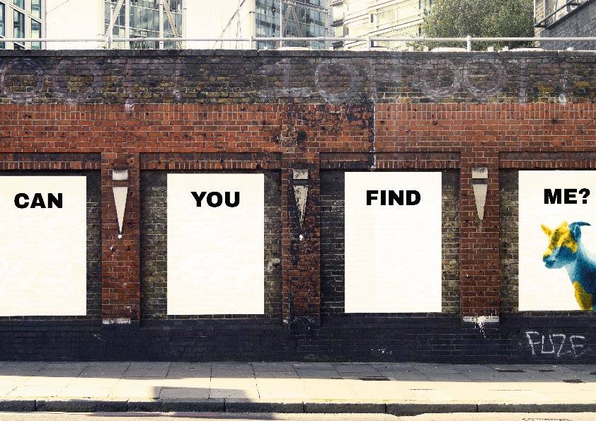 Un mural en una pared con palabras que invitan a buscar algo y una vaca de colores en la esquina.