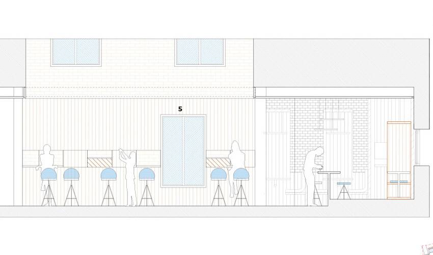 Se presenta un plano de sección de un espacio que muestra varias áreas con asientos y mesas.