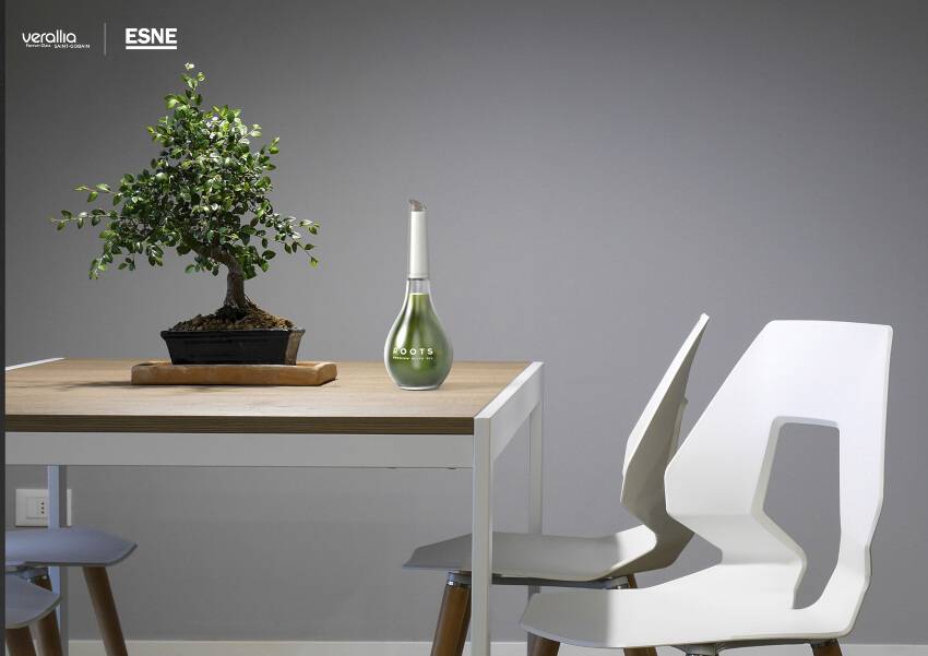 Una mesa moderna con una planta bonsai y un recipiente decorativo en un entorno minimalista.