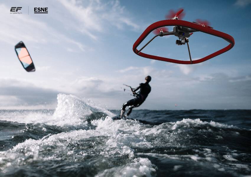 Un kitesurfista surca las olas mientras un dron vuela por encima de él.