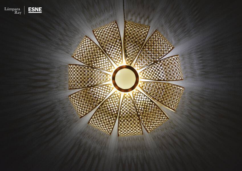 Una lámpara de diseño circular con un patrón ornamental que emite luz en forma radial.