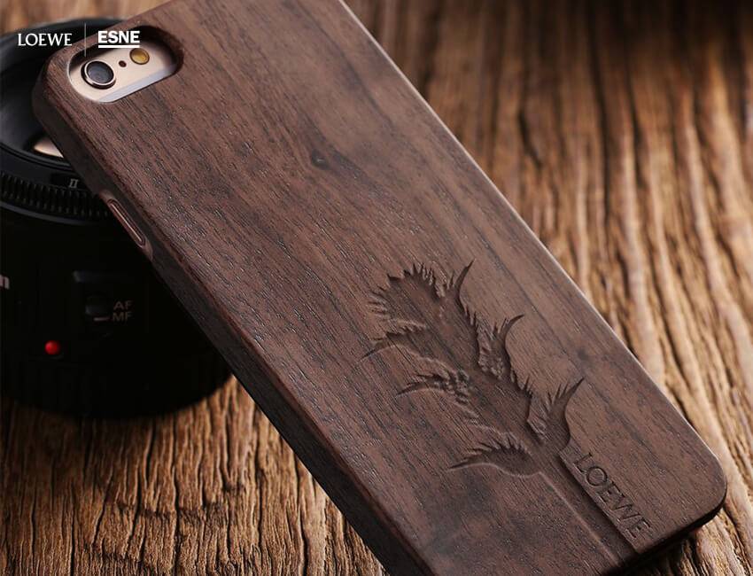 Una funda de teléfono móvil de madera con un diseño grabado de una planta.
