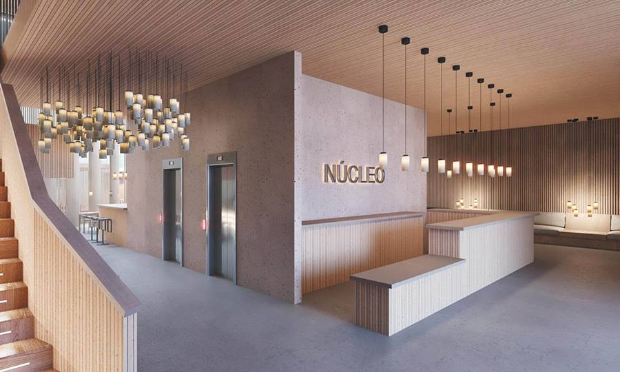 Interior moderno y acogedor de un vestíbulo con elementos de diseño en madera y luces colgantes.