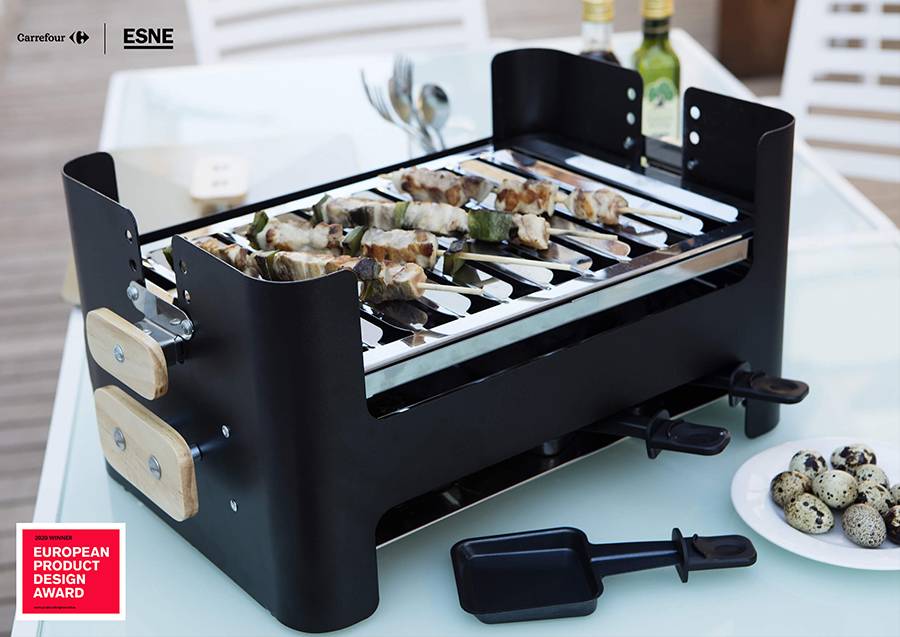 Una parrilla portátil de diseño moderno con brochetas cocinándose sobre ella.