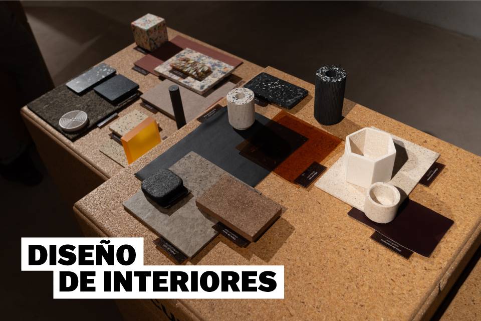 Muestra de materiales y objetos para diseño de interiores dispuestos sobre una mesa.
