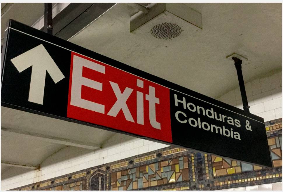Una señal de salida en una estación de metro que indica dirección hacia Honduras y Colombia.