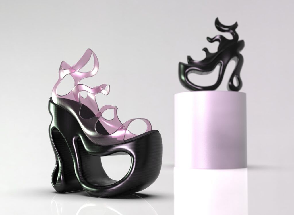 Una imagen que muestra un par de zapatos de tacón de diseño moderno y artístico, uno en colores negro y rosa, y otro como una figura decorativa en una base.
