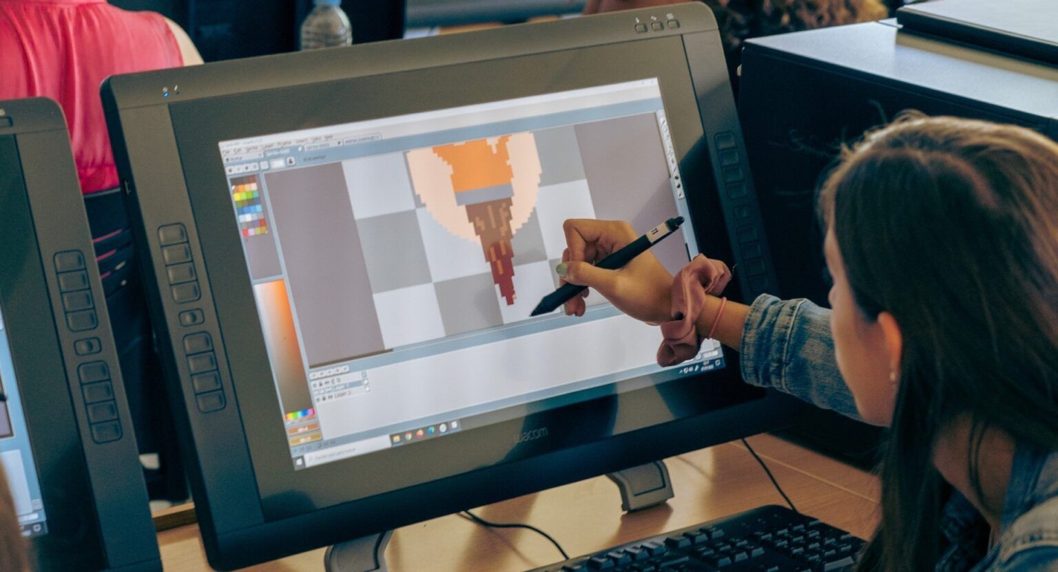 Una persona está dibujando en una tableta gráfica mientras trabaja en una ilustración digital.