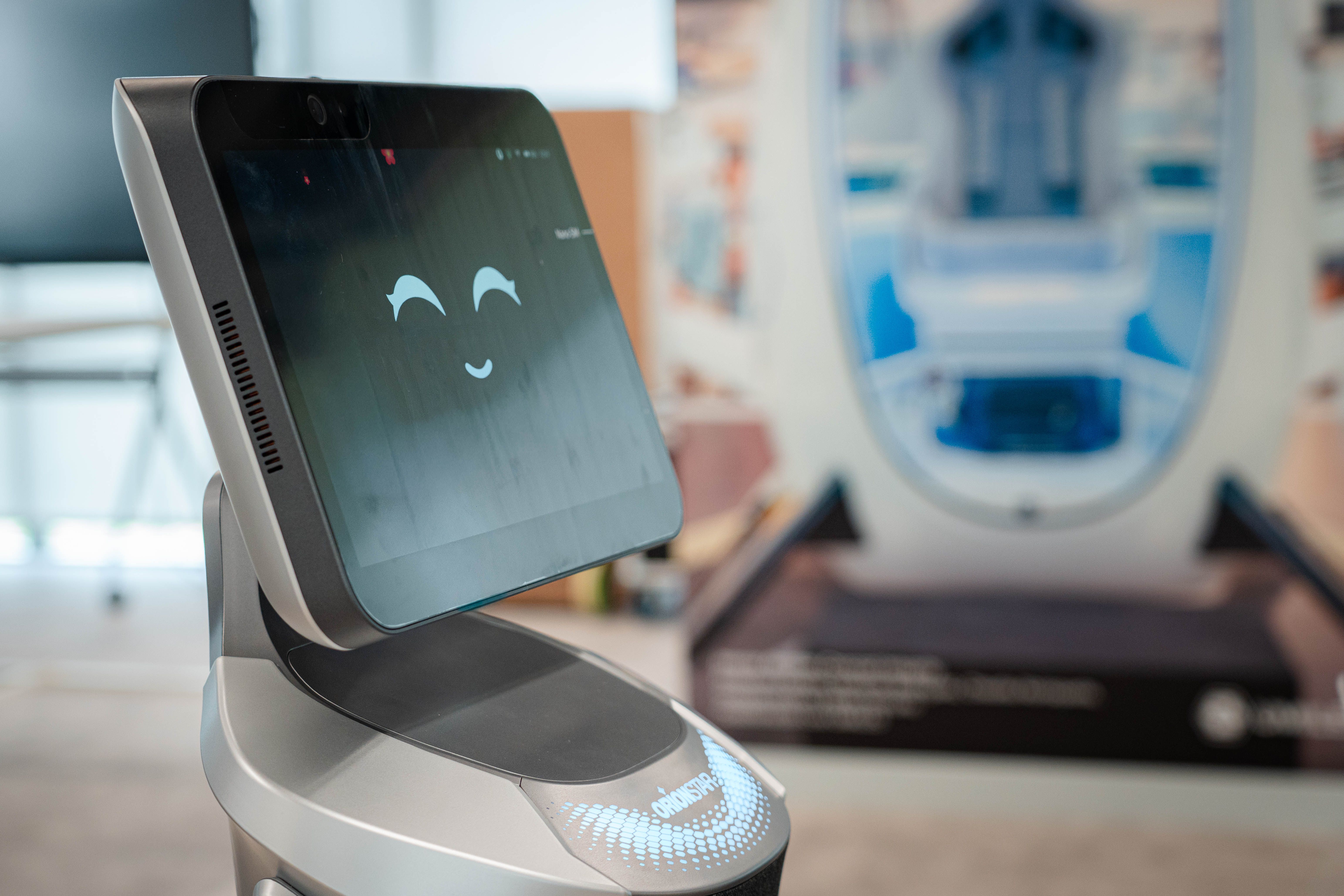 Un robot con pantalla sonriente en un entorno moderno.