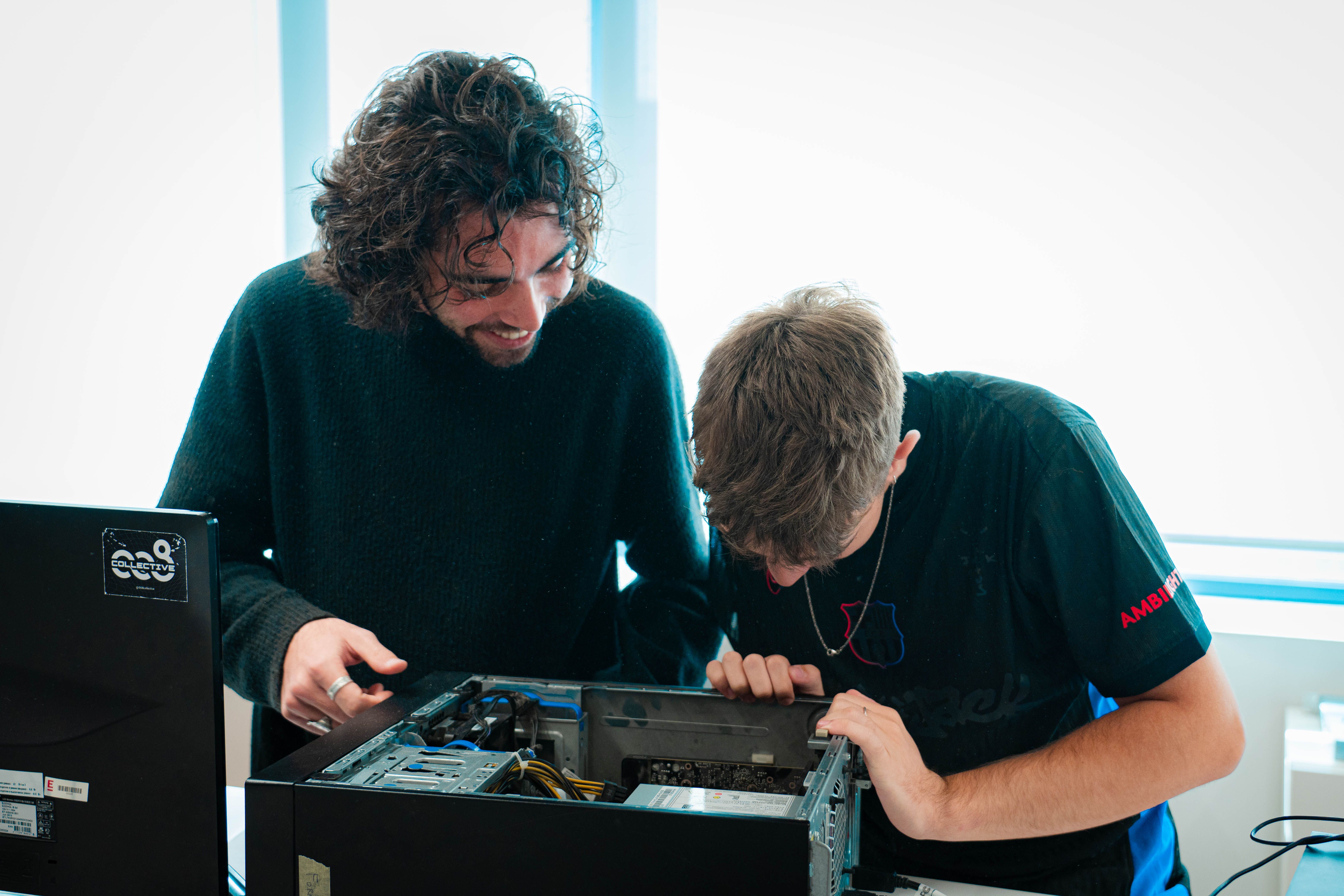 Dos jóvenes entusiastas están trabajando juntos en la reparación de una computadora.