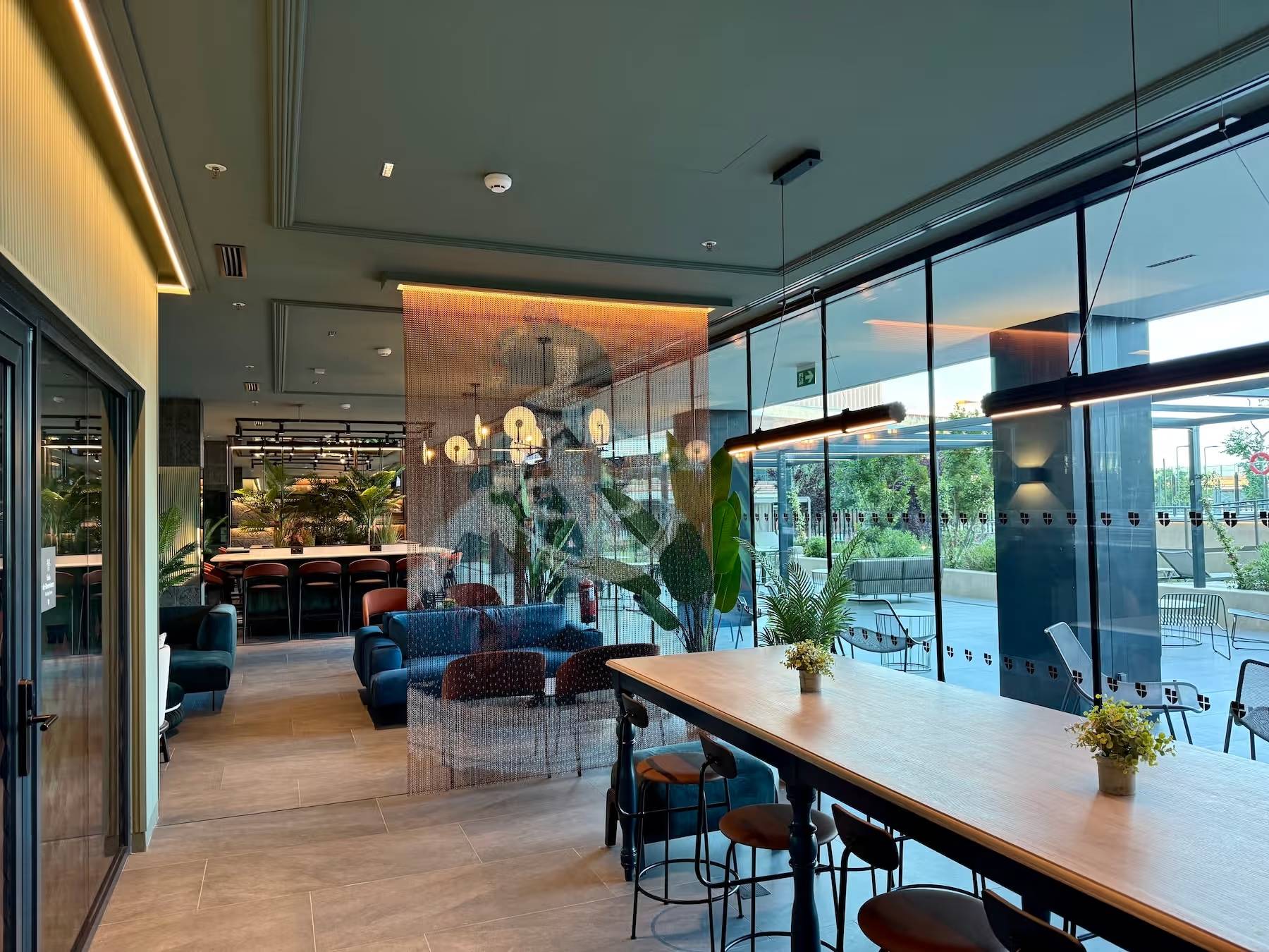 Interior de un moderno café con mobiliario acogedor y vistas al exterior.