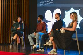 Una charla en un evento donde cuatro personas discuten sobre la experiencia de productos y servicios.