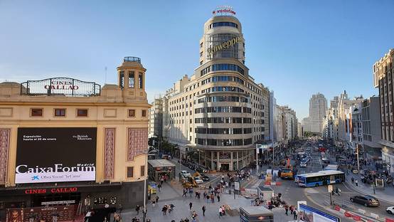 Vista de la Plaza de Callao en Madrid con edificios emblemáticos y tráfico urbano.