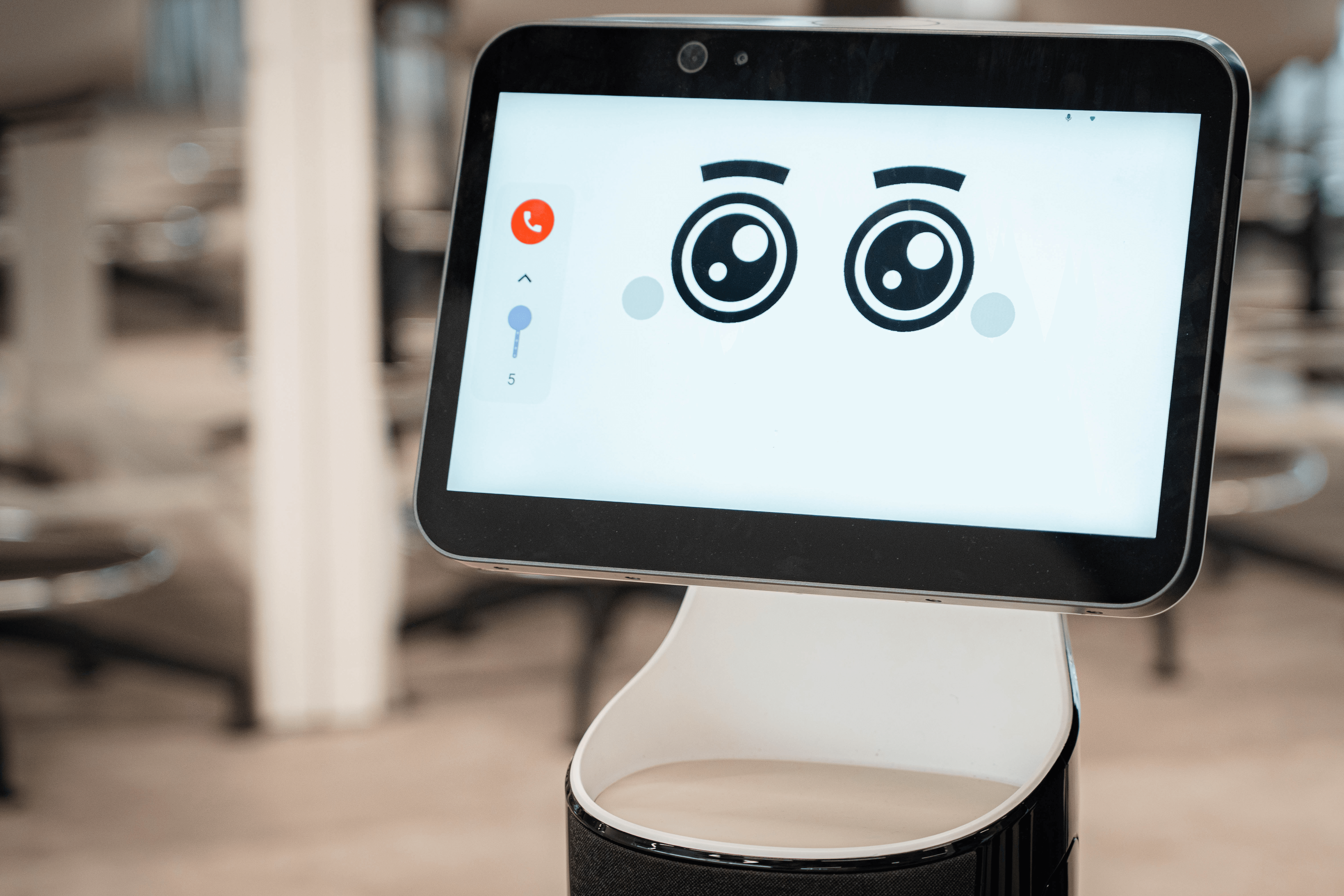 Un robot con una pantalla que muestra ojos grandes y expresivos.